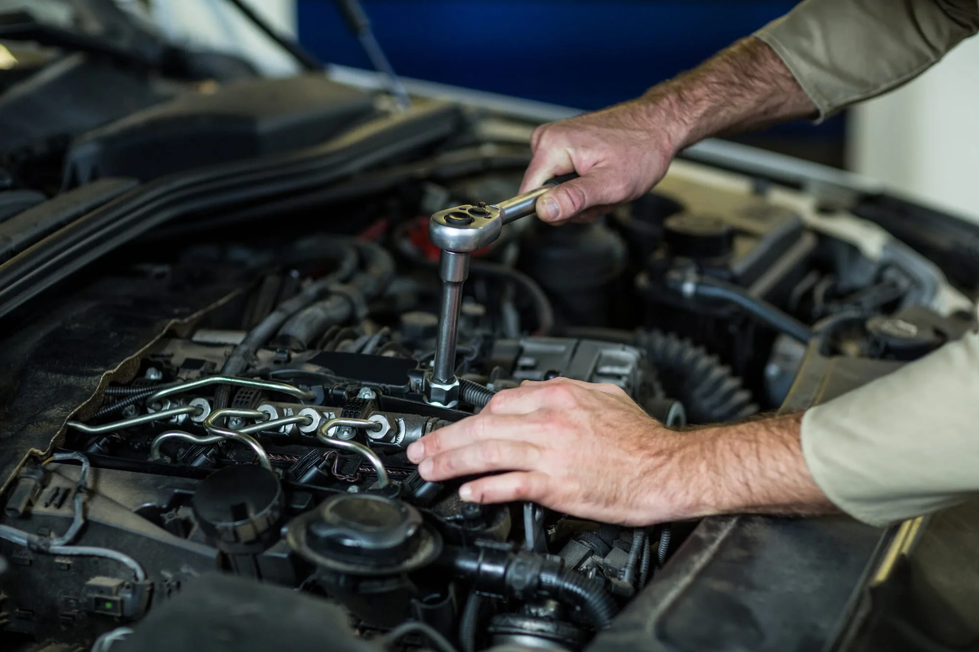 Mecânico da Júnior Automáticos reparando motor de veículo com câmbio automático